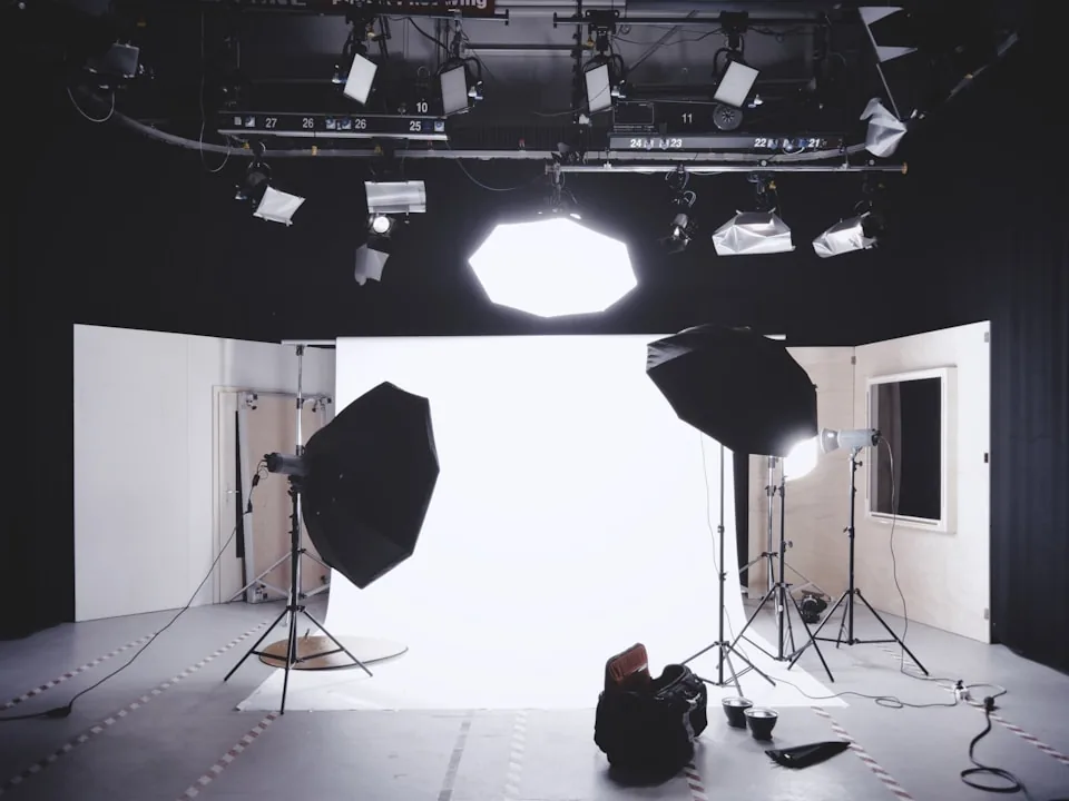 Appareil sur trépied, fond de studio et sources lumineuses organisés pour une prise de vue